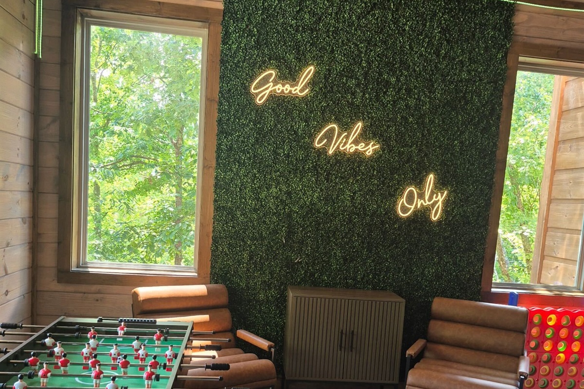 Fun corner with “Good Vibes Only” neon sign and chairs