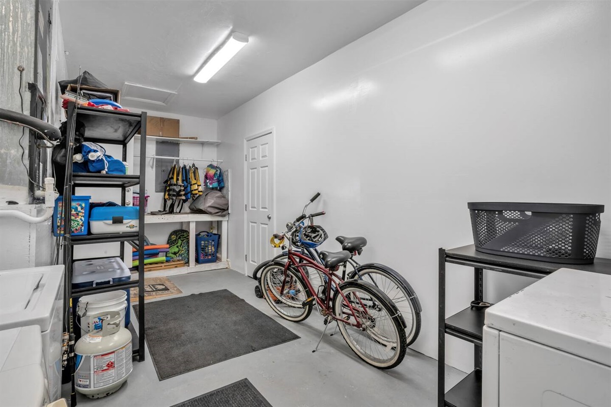 Laundry room with bikes, life jackets, and "toys" for your use.