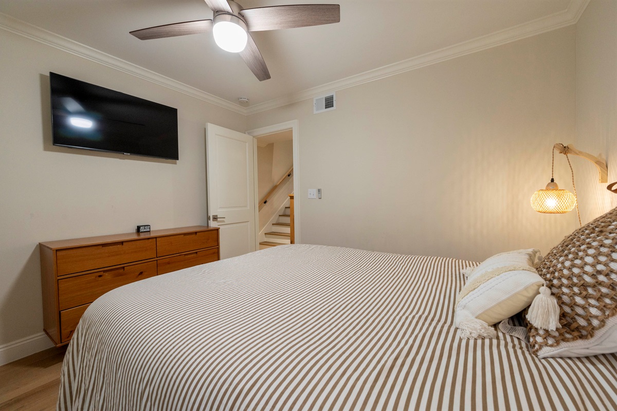 A warm and inviting bedroom with soft lighting, cozy textures, and a modern coastal feel.