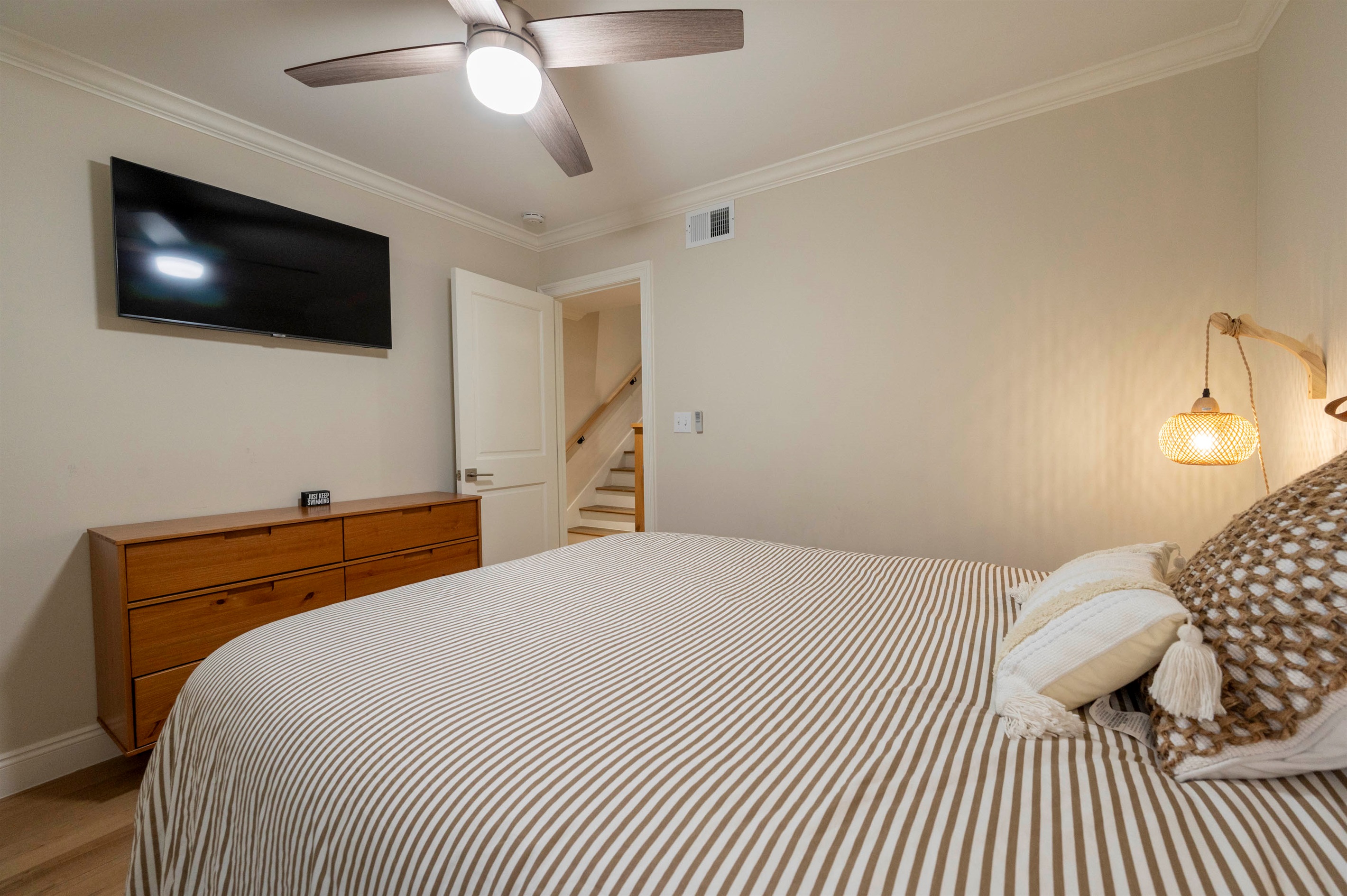 A warm and inviting bedroom with soft lighting, cozy textures, and a modern coastal feel.