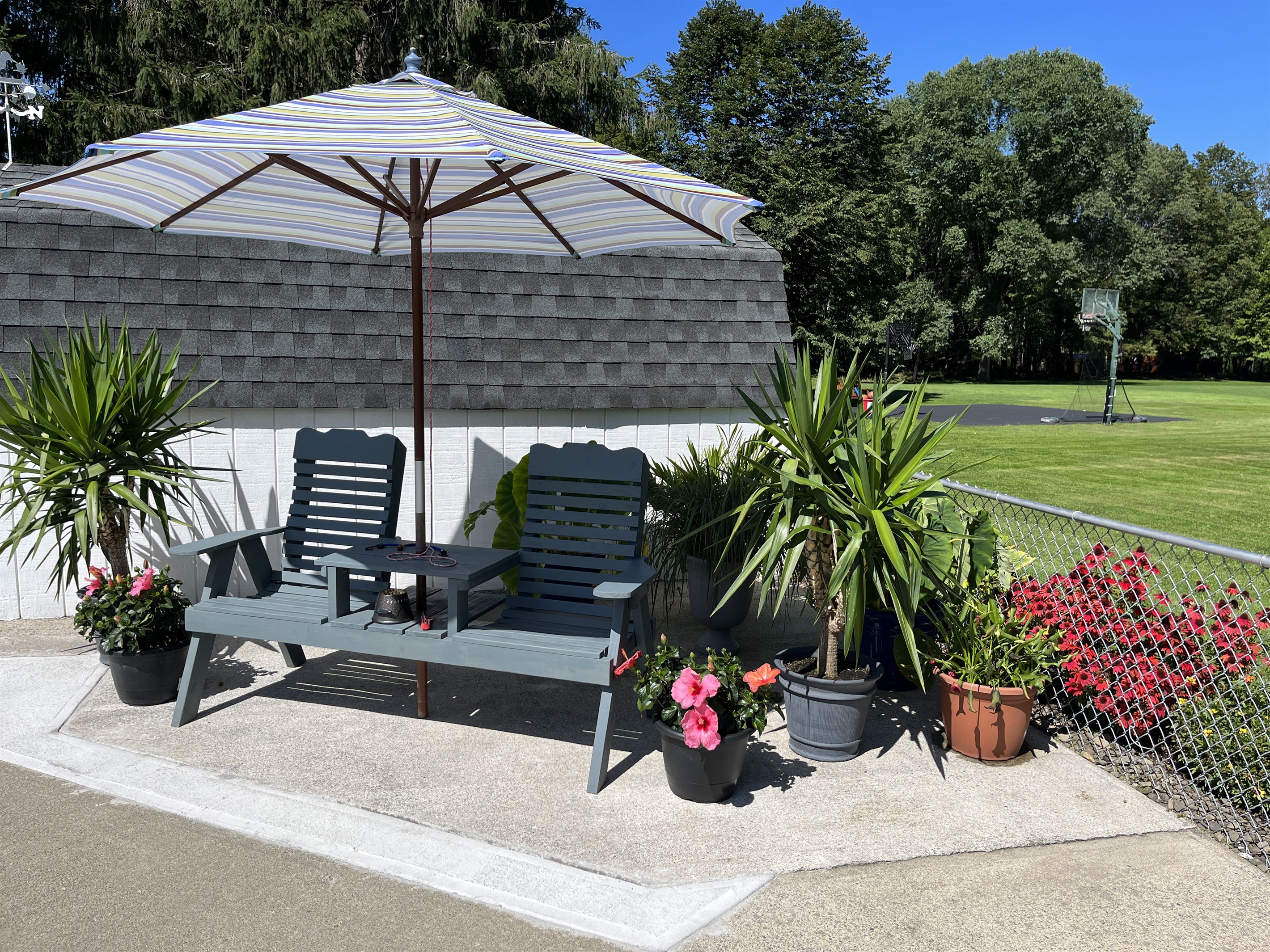 Seating area next to pool with basketball hoop beyond