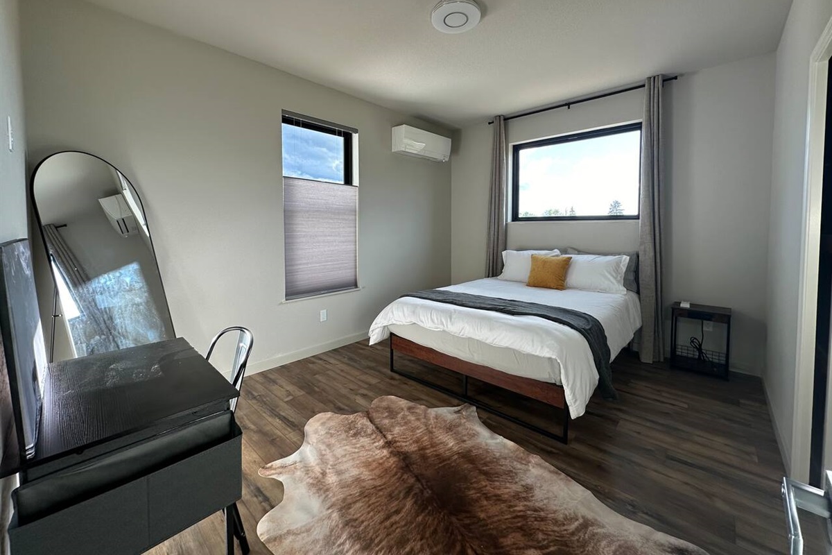 Sleep well one of the two spacious bedrooms.  Each had a walk-in closet, queen bed, luxury linens, full length mirror, own mini-split and bathroom.   The gorgeous picture windows have blackout curtains for night.  This room has a work station.  