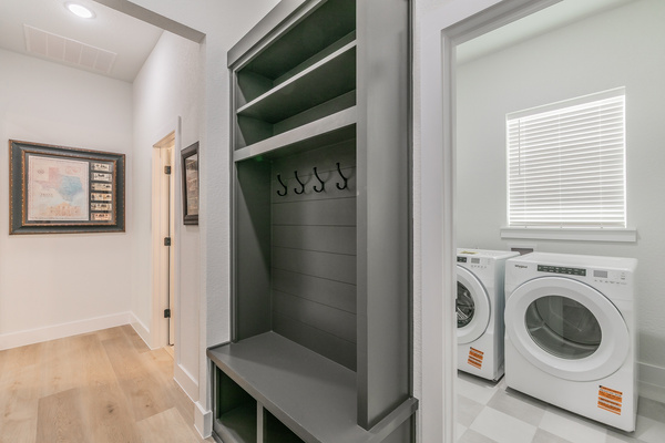 Hall tree for coats and shoes next to the laundry room