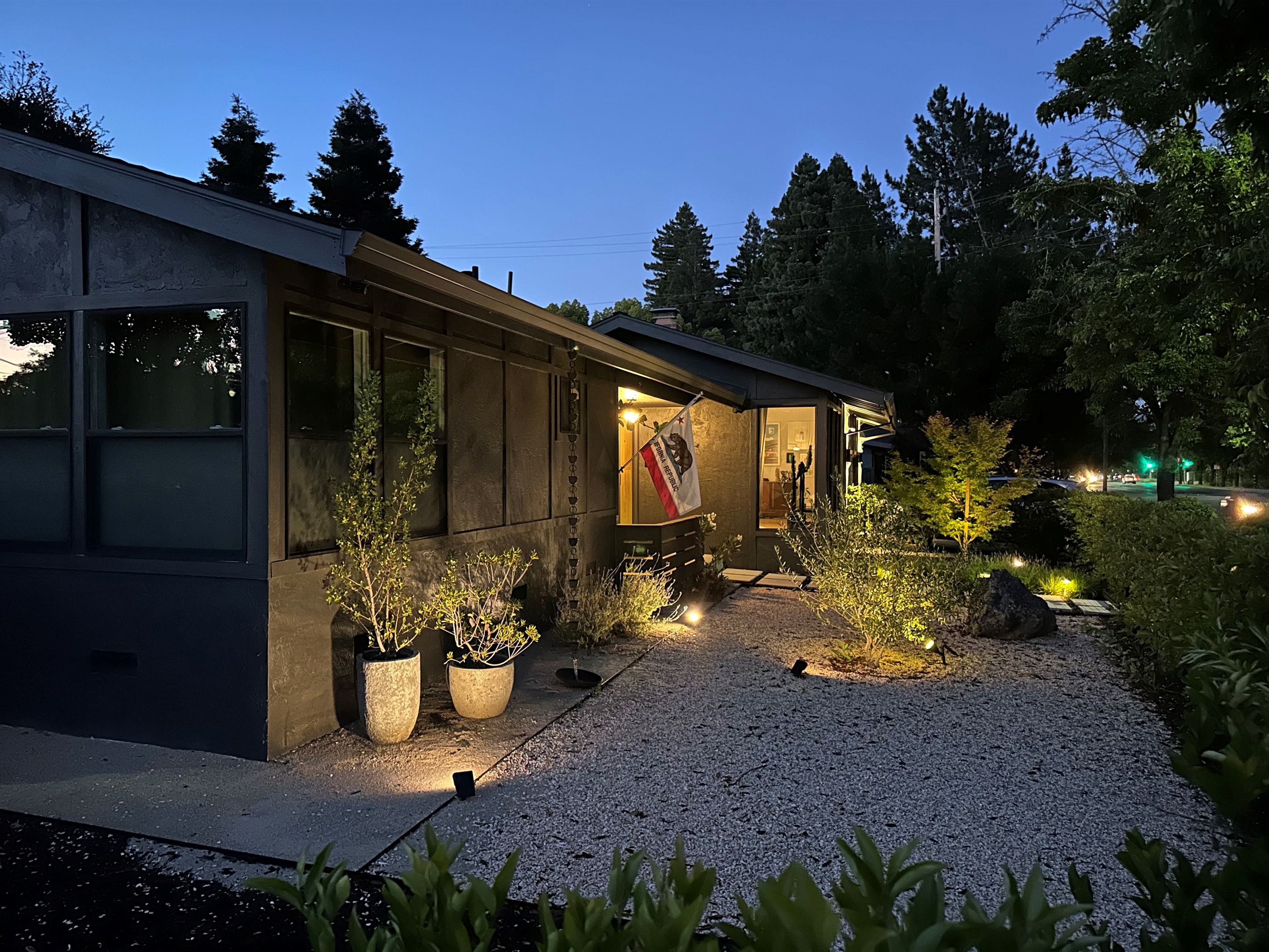 As the sun sets, the property transforms into a warm and inviting retreat with elegant outdoor lighting that creates the perfect ambiance for evening gatherings, outdoor dining, and relaxing under the stars.