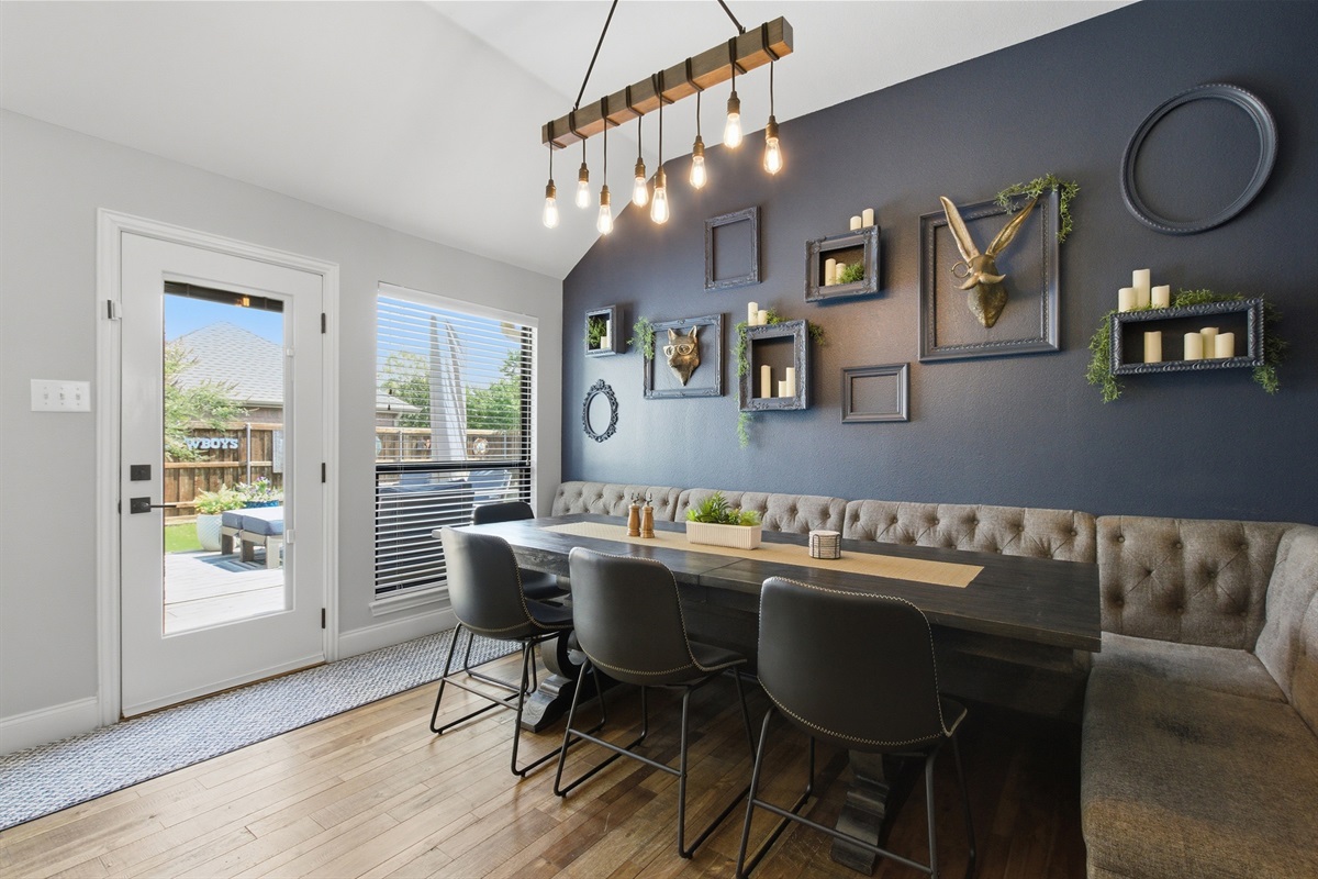 Dining Room with a long Dining Table seating 8, statement pendant lighting, a comfortable banquette, and direct access to the Backyard.
