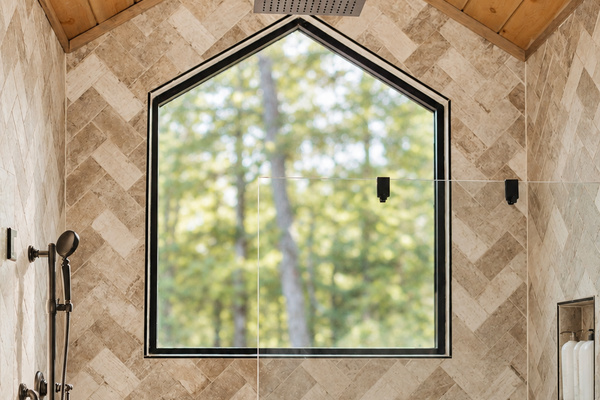 Spacious shower with a rain showerhead.
