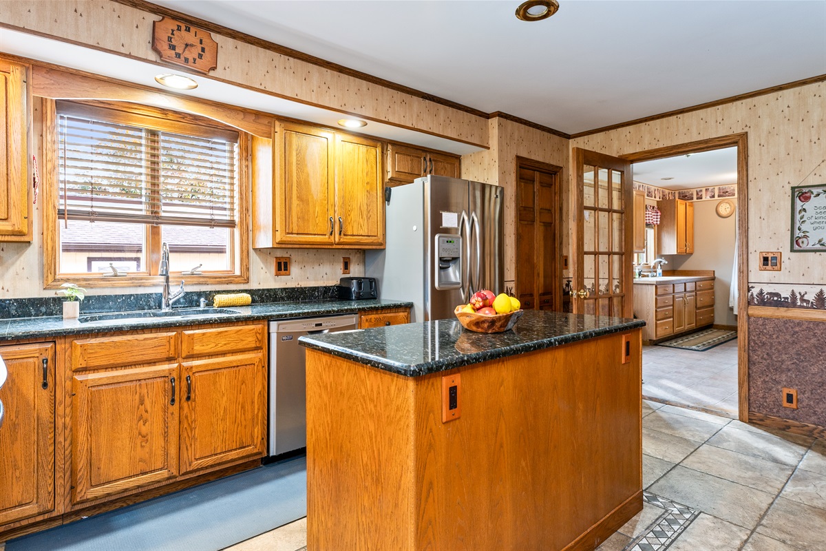 Spacious kitchen with island seating and stainless-steel appliances, perfect for cooking up family favorites.