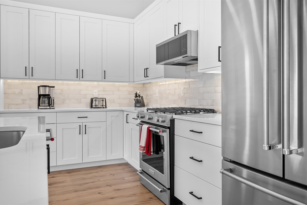 Fully equipped modern kitchen with stainless steel appliances and ample cabinet space.