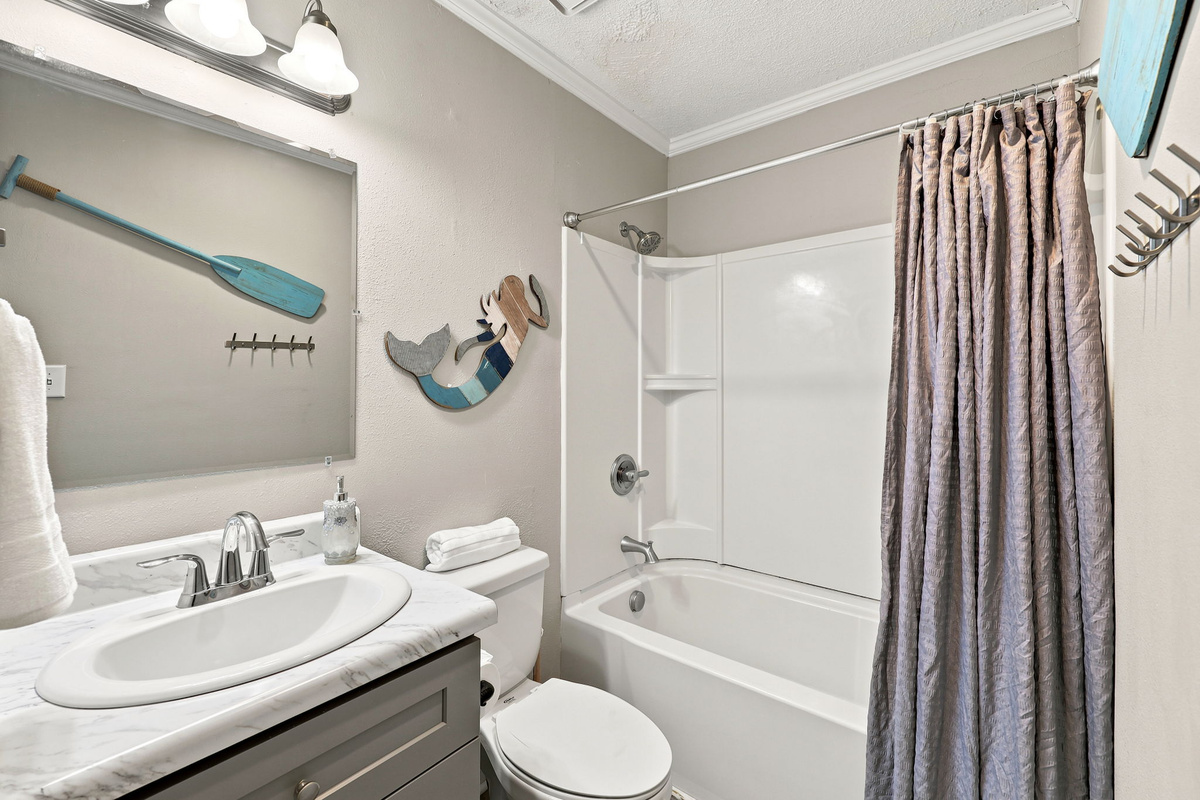 A clean and functional bathroom featuring a spacious vanity, fresh towels, and coastal-inspired accents
