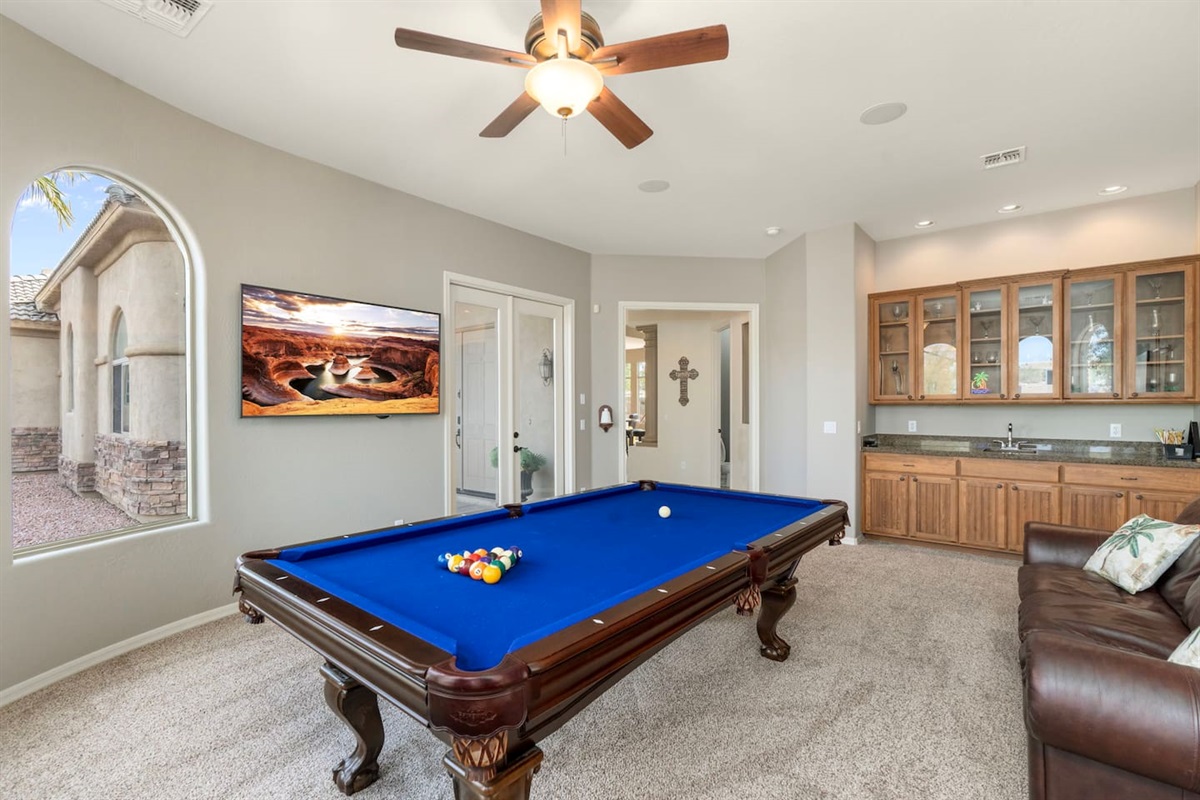 Game room fun starts here with a full-size pool table, wall-mounted TV, and relaxed seating.
