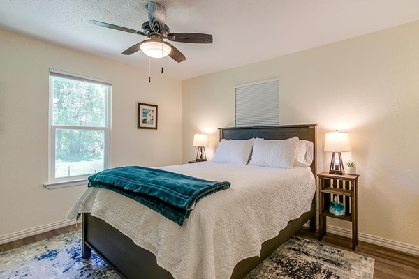 Comfortable queen bedroom with Smart TV and natural light — a peaceful retreat after a day on Lake Granbury.