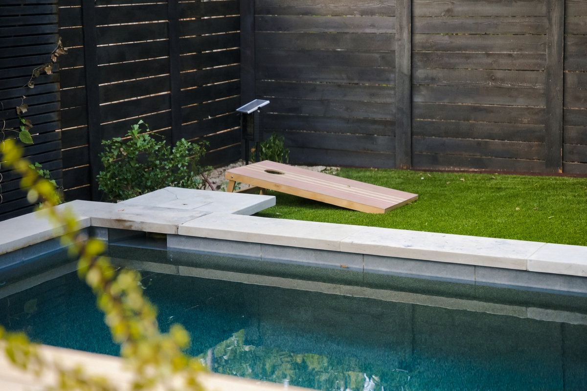 Sleek lap pool and a cornhole board for game day.