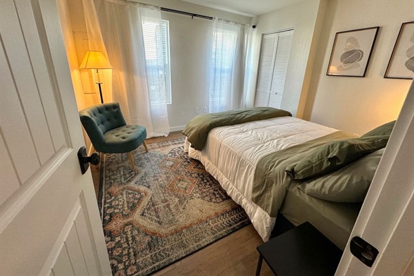 This bedroom features a queen bed, black out curtains, and generous closet space. 