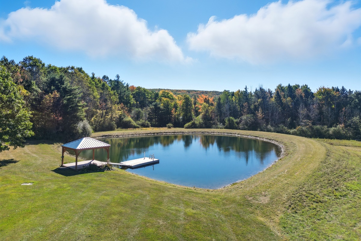 Private pond with seating for relaxing days outdoors.