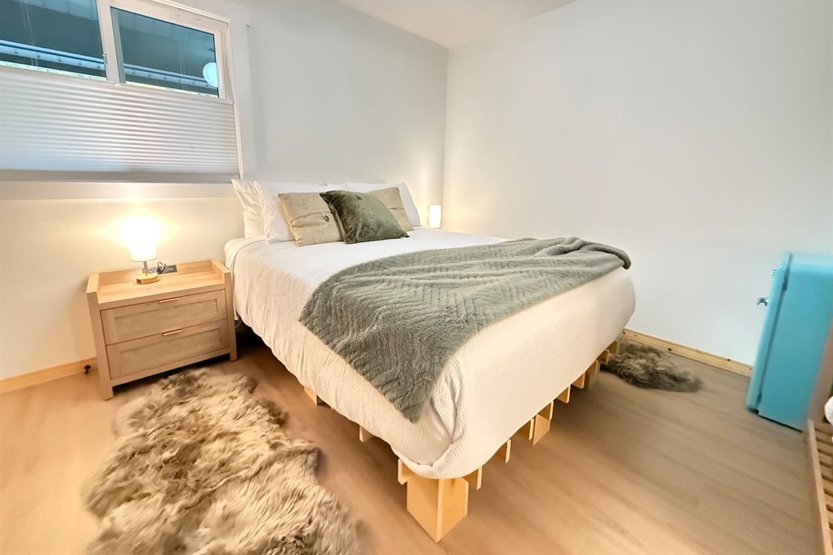 Cozy queen bed with dual nightstands featuring outlets, USB and USC ports, and dimmable touch lamps for a comfortable, connected stay. (Artwork coming soon.)
