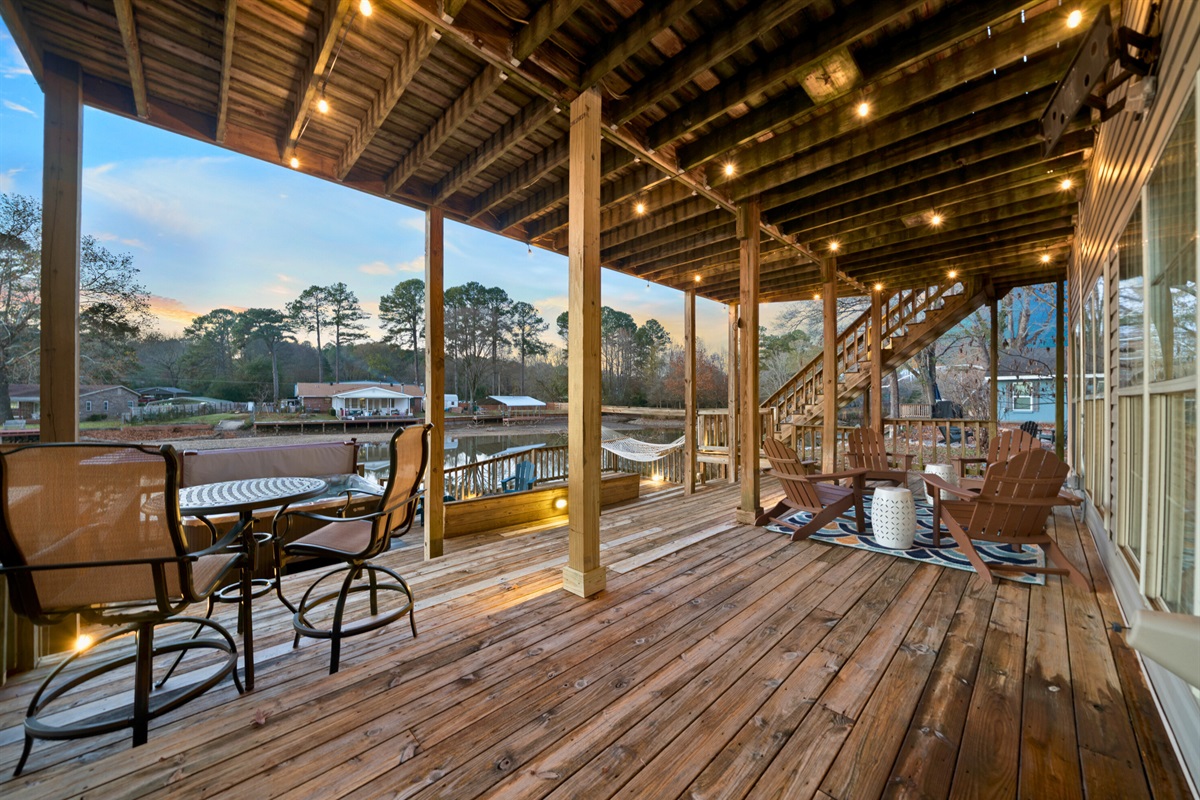 The wide lower deck stretches along the water and offers plenty of space to dine, lounge, and enjoy long conversations against a peaceful lake backdrop.