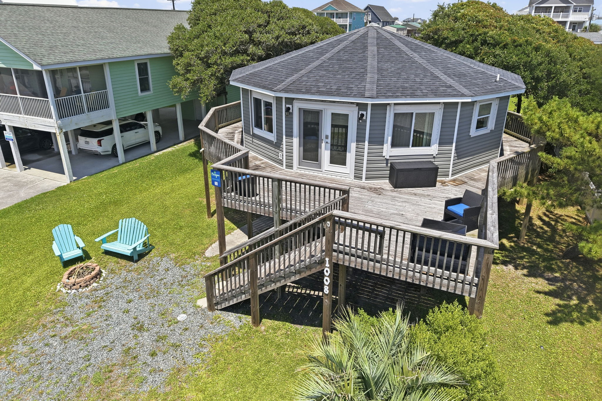 A unique octagon-shaped beach home with wraparound deck, spacious yard, and inviting outdoor seating
