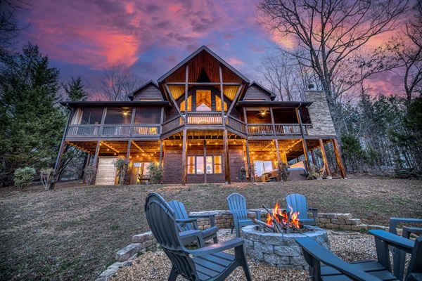 Fire pit in the back of the beautiful "Blessed Sunset" mountain retreat home overlooking the back yard! Stunning A-frame, wrap-around porch, screened-in patio, outdoor fireplace, outdoor dining table, sauna, hot tub, outdoor couch, and more!
