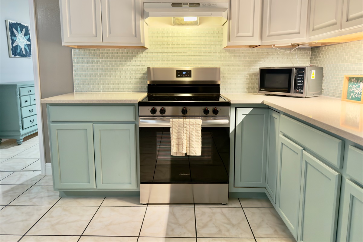 Soothing two-tone cabinetry in crisp white and soft seafoam green gives this kitchen a light, airy feel.