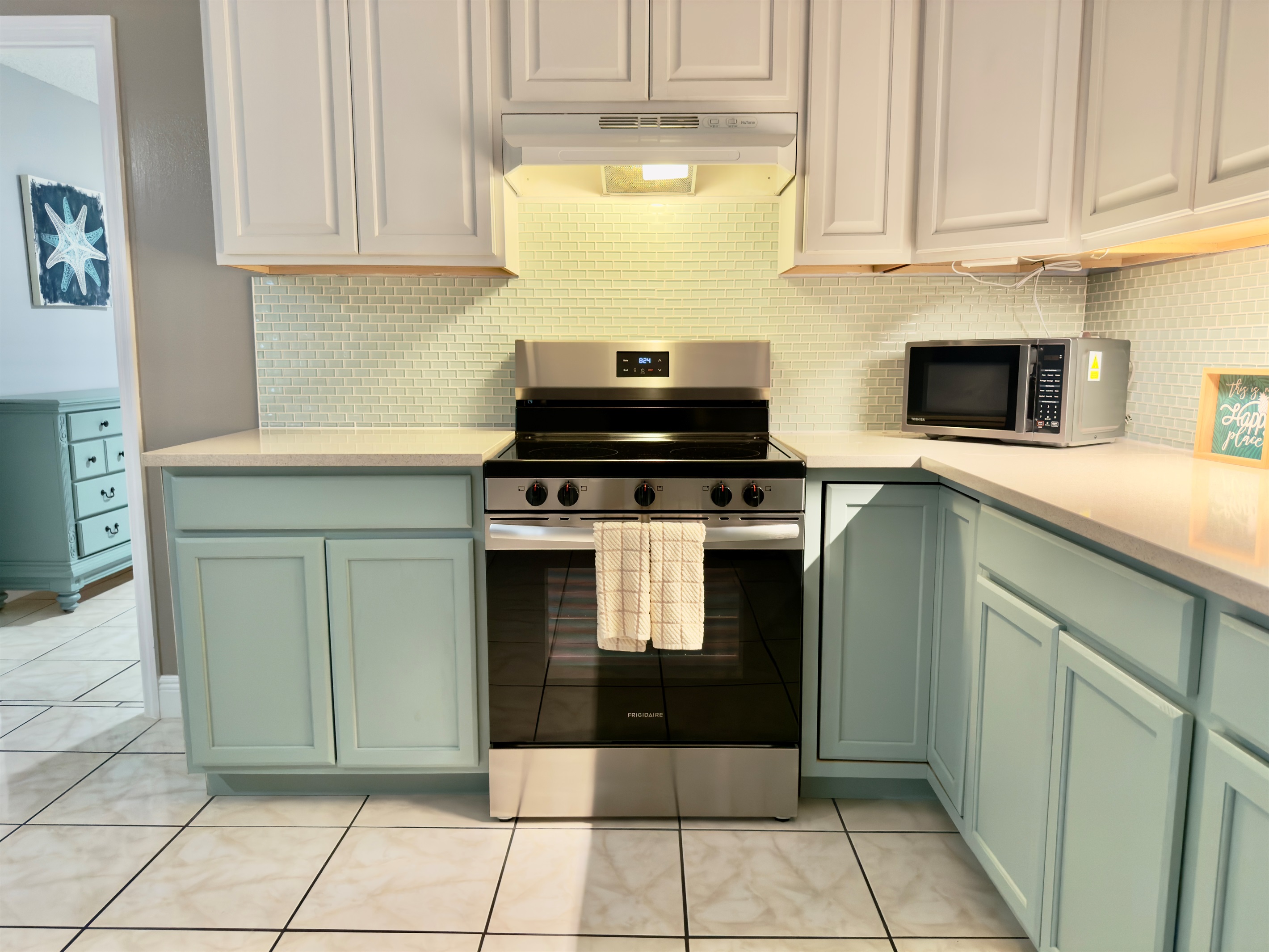 Soothing two-tone cabinetry in crisp white and soft seafoam green gives this kitchen a light, airy feel.