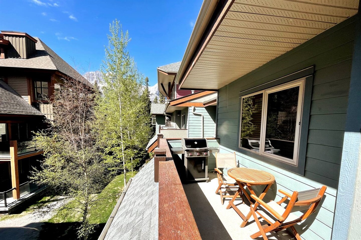 Balcony with natural gas webber BBQ, table, and chairs.