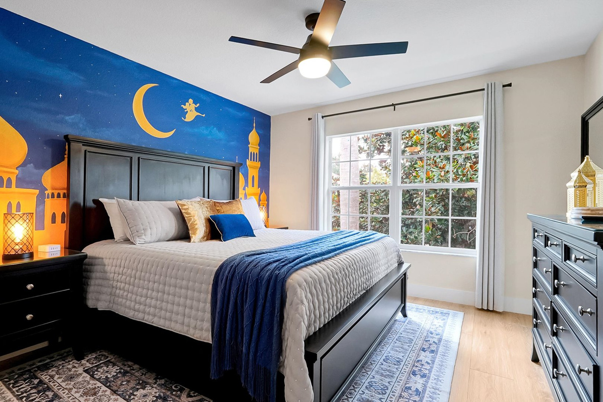 Aladdin King Suite: King-size bed framed by a dramatic palace mural and warm lantern-inspired lighting.