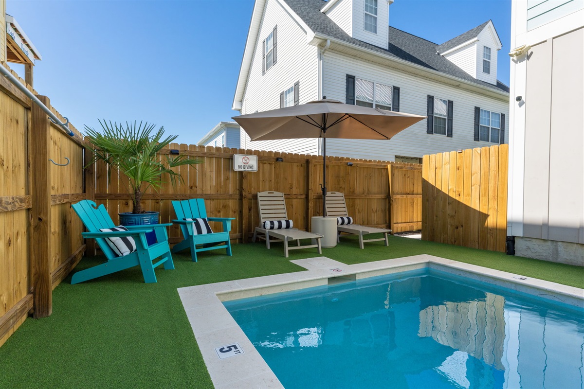 Fully fenced private pool with loungers, shade, and seating.