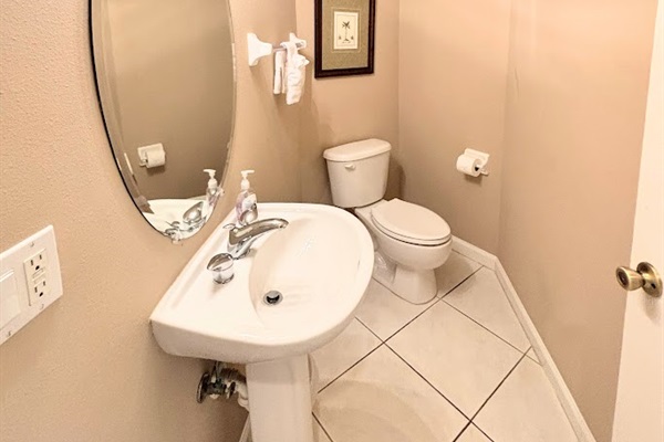 Convenient half bathroom with pedestal sink, tile flooring, and clean, neutral finishes.