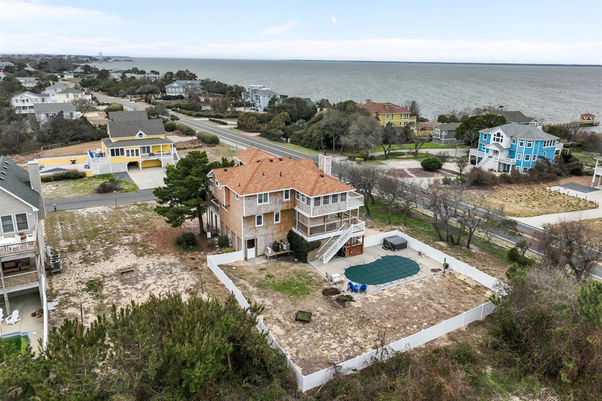 Aerial of the home with private pool and open yard space, great for relaxing outside.