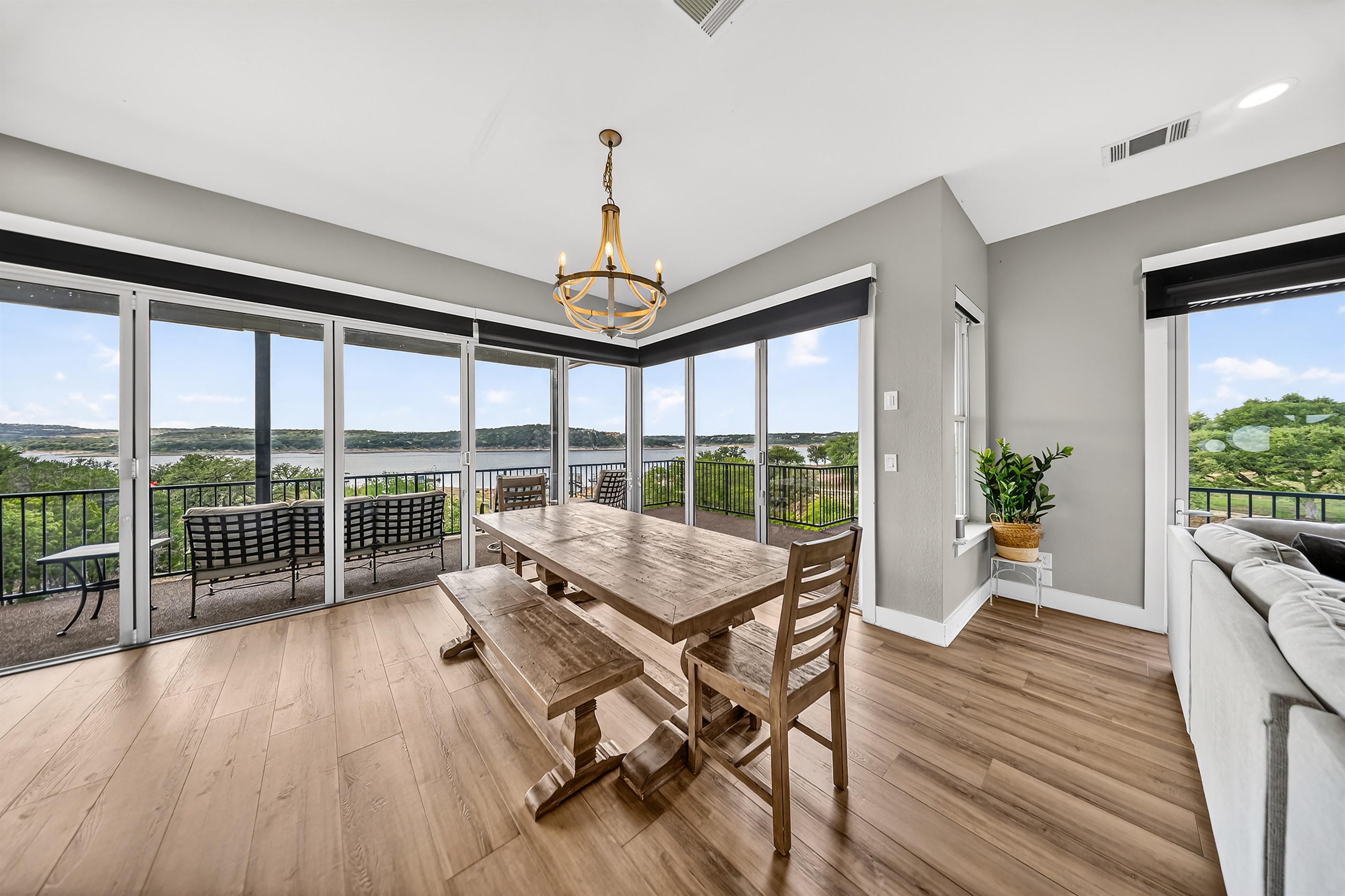 Lakeview dining room, with its rustic table, is perfect for group meals. The bright natural light enhances every mealtime memory shared together. The open design seamlessly connects the kitchen, patio, and living area, creating a relaxing flow.