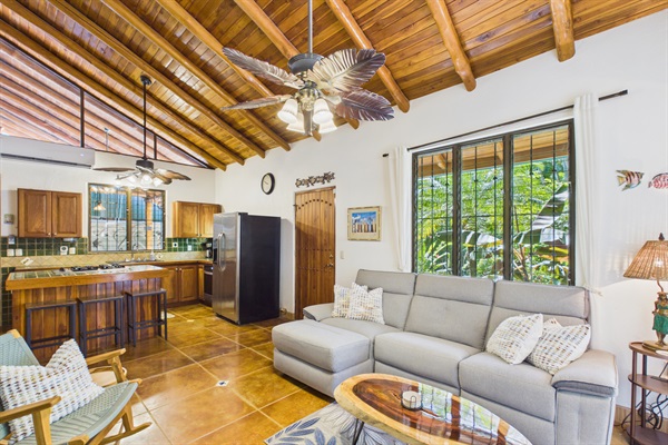 Living room with vaulted wood ceiling and open kitchen.  Sofa with Electric recliner