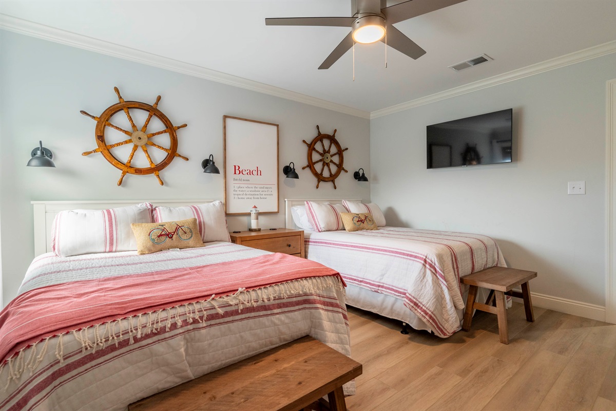Charming bedroom with twin beds, striped decor, and nautical coastal vibes.
