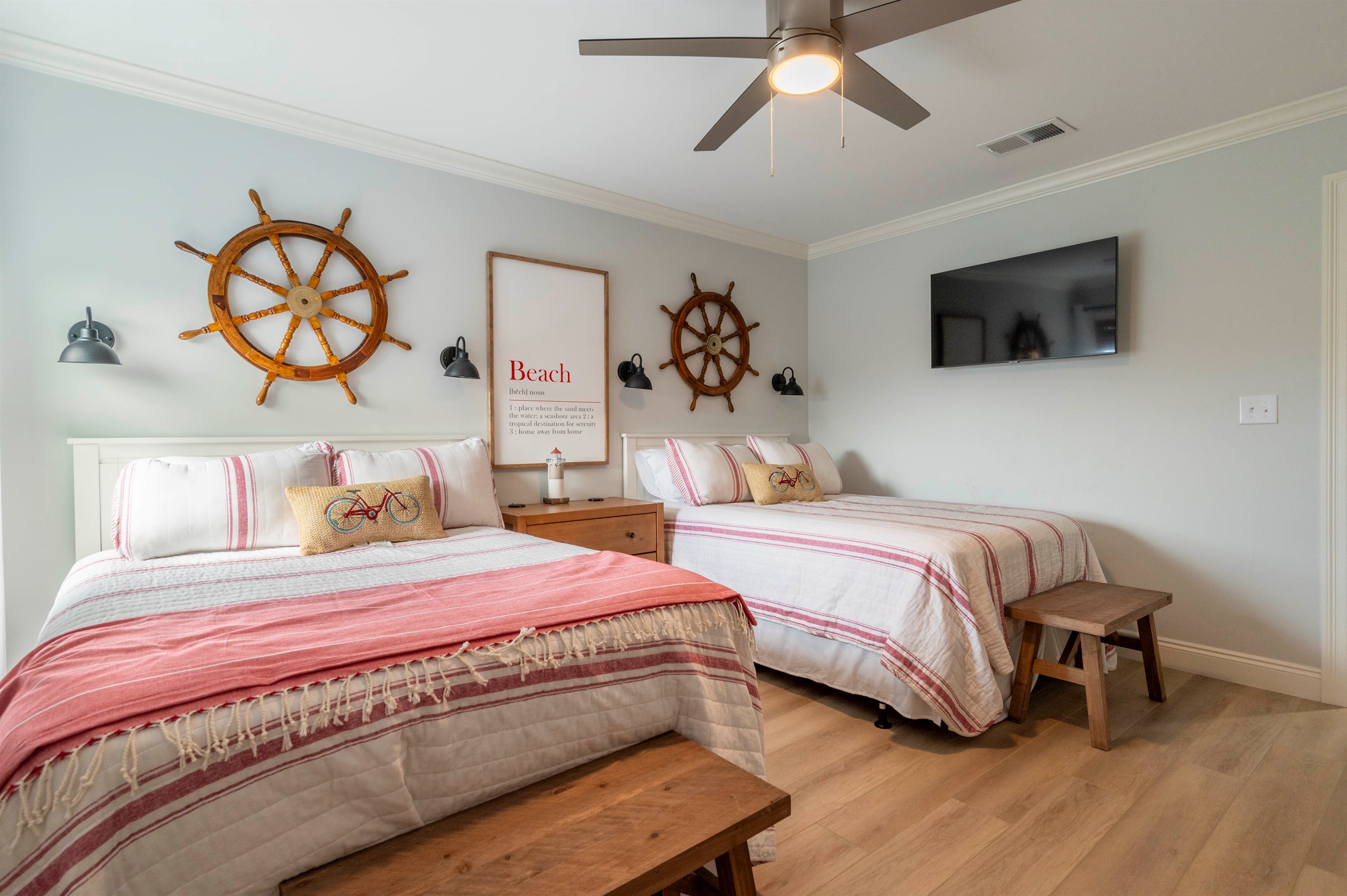 Charming bedroom with twin beds, striped decor, and nautical coastal vibes.