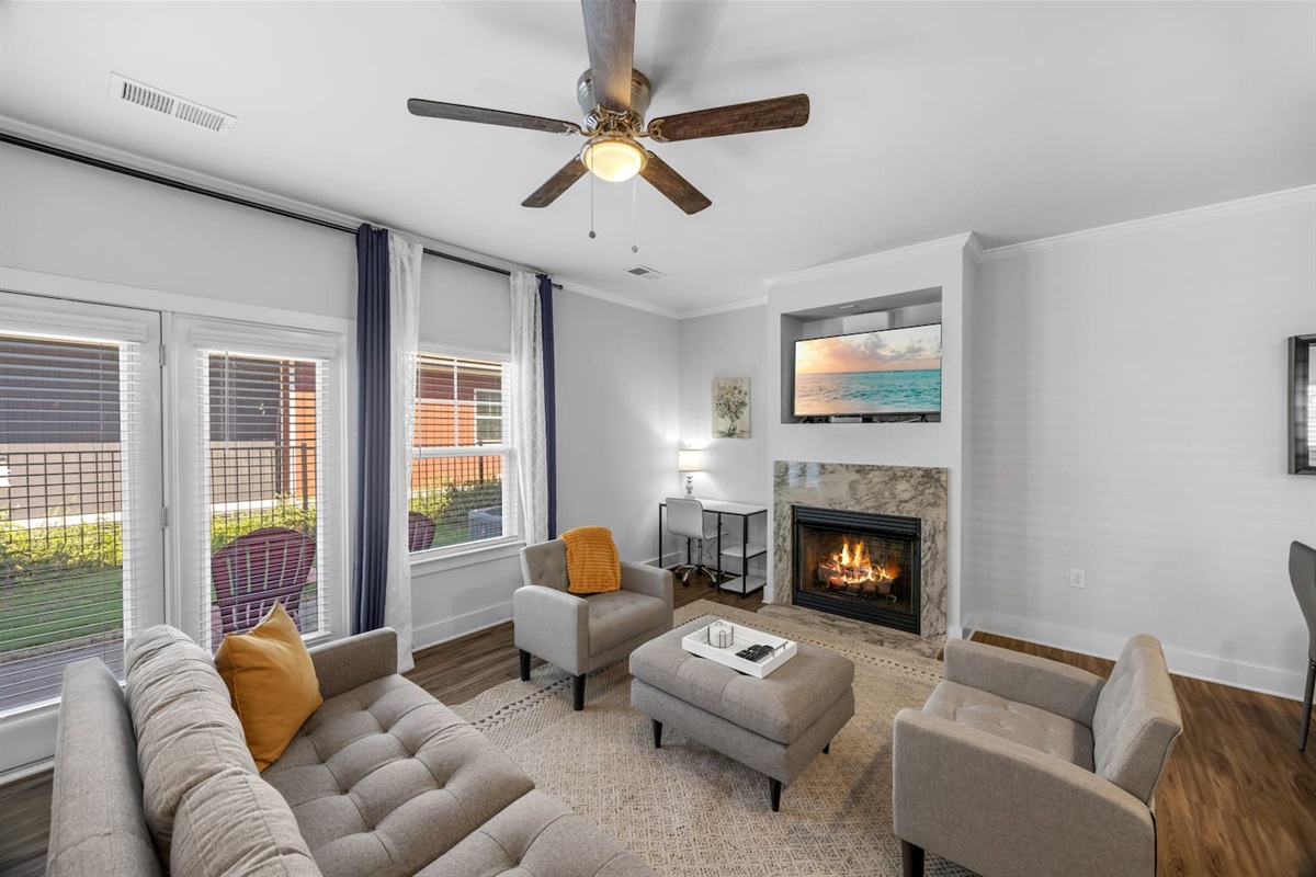 Relax in a stylish space with plush seating, natural light, and a warm fireplace for cozy evenings.