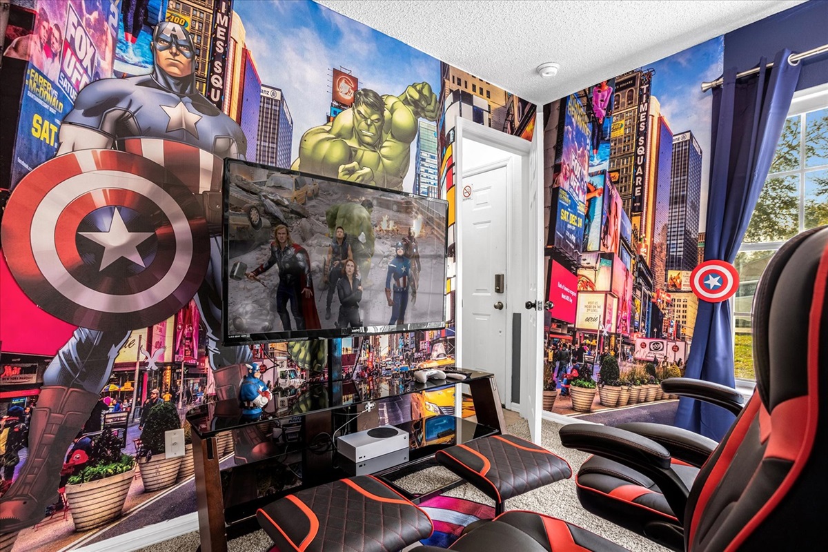 Marvel bedroom featuring avengers-themed wall art, Xbox, gaming chairs, 65" TV