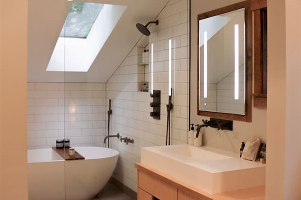 Natural light comes in through the skylight, beautiful tile work accented by Watermark fixtures
