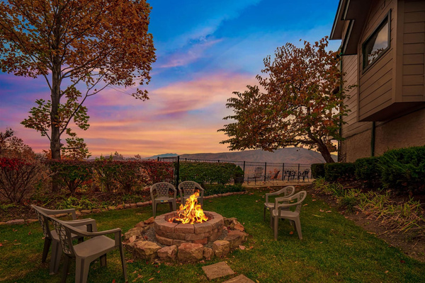 Outdoor fire pit with wood provided, glowing at twilight, Tanasi Lodge