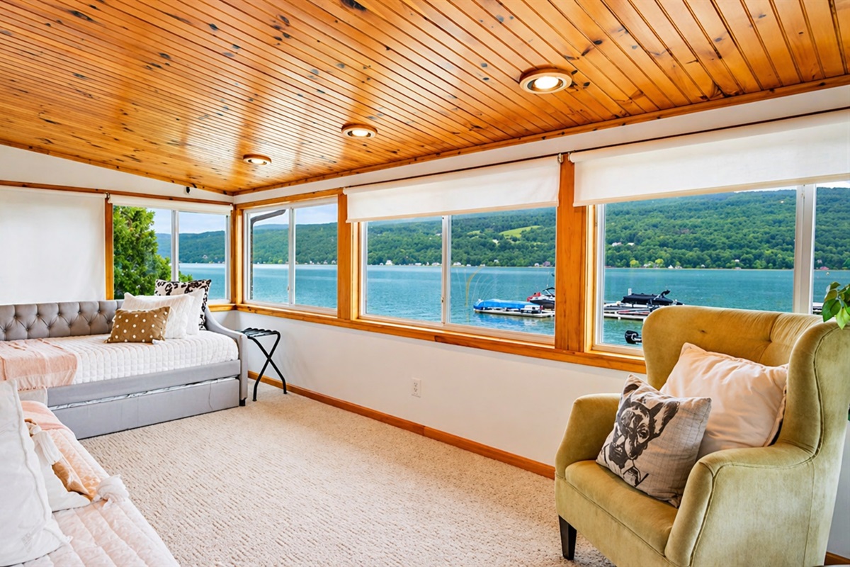 Enjoy peaceful lakeside views from this cozy sunroom, complete with plush seating for ultimate relaxation. 🌅🛋️🌊