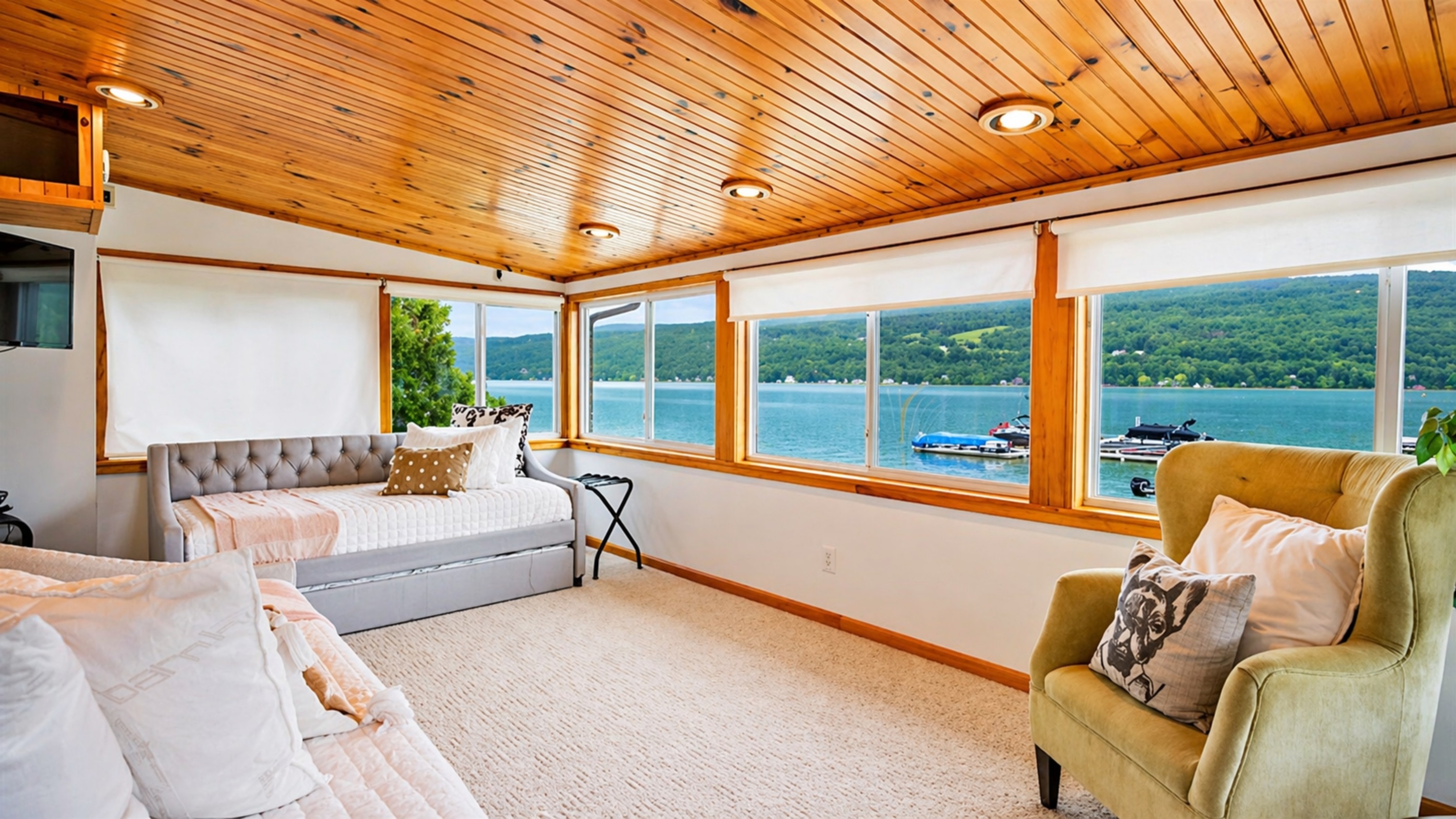 Enjoy peaceful lakeside views from this cozy sunroom, complete with plush seating for ultimate relaxation. 🌅🛋️🌊