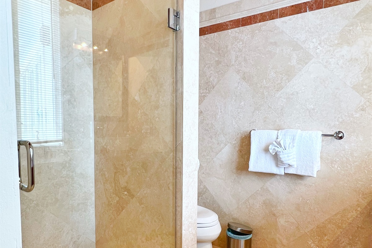Travertine lined bathroom with a walk-in shower.