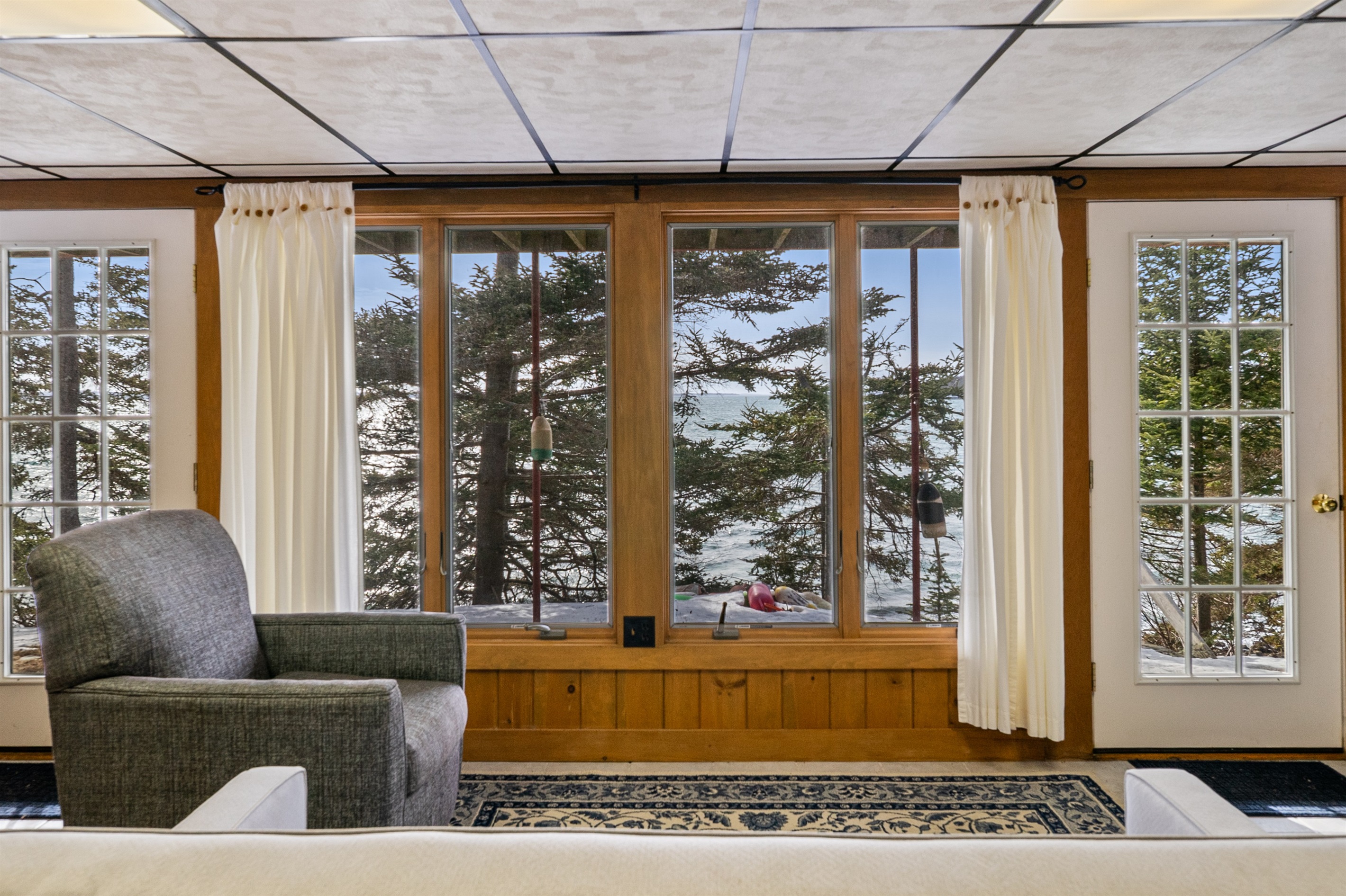 A bright, wood-paneled secondary living space offering privacy and quiet harbor views.
