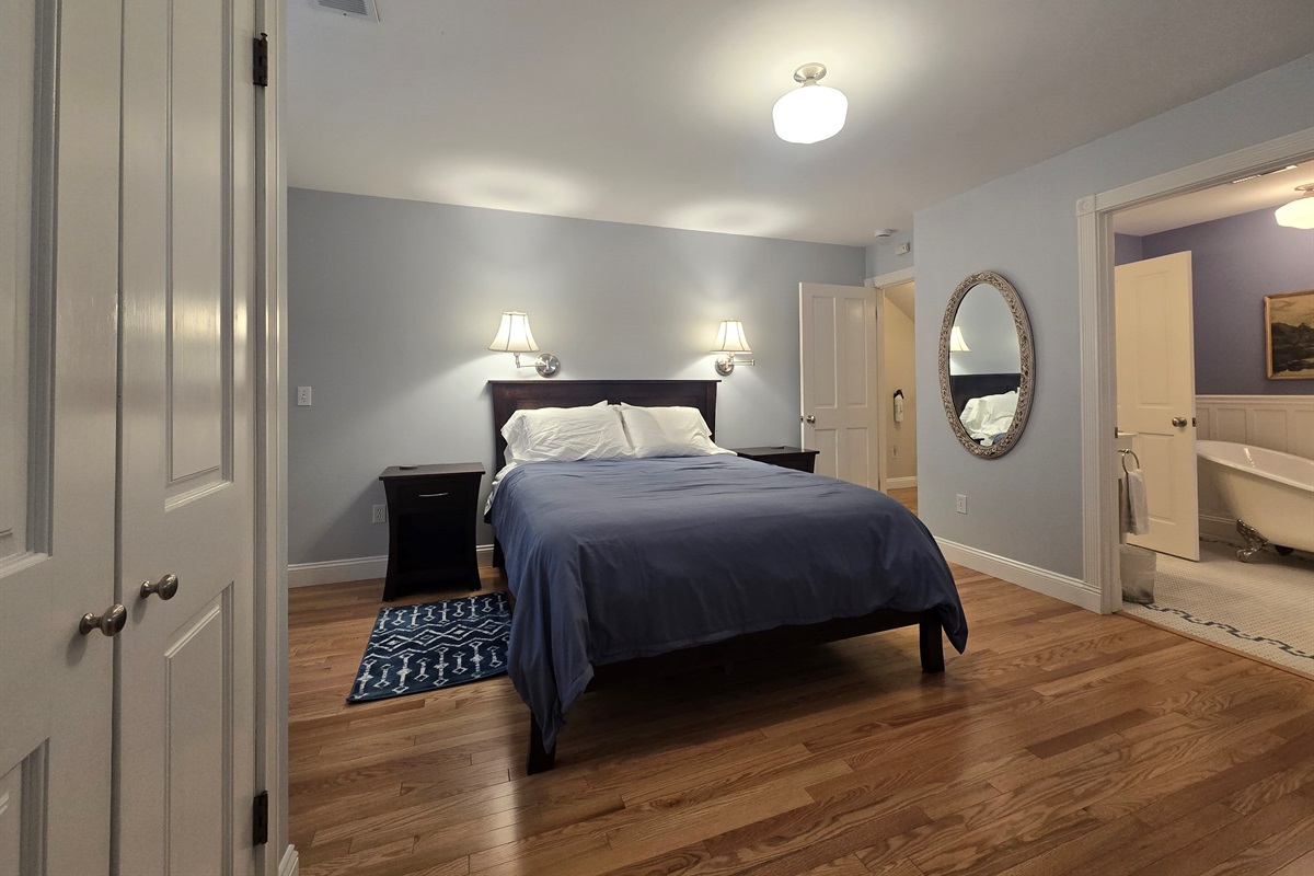Primary Sea bedroom with red oak flooring, handmade cherrywood furniture