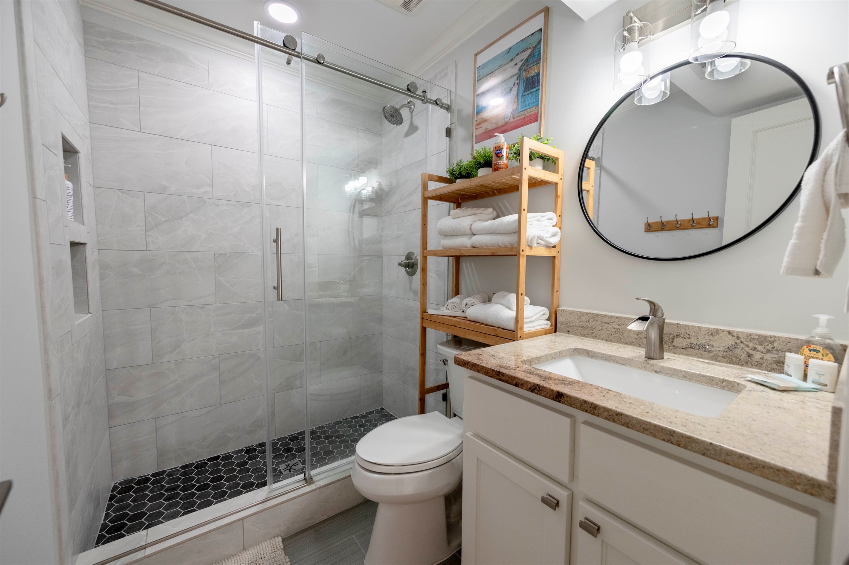 Modern elegance: Glass shower, sleek vanity, and warm wooden accents for style.