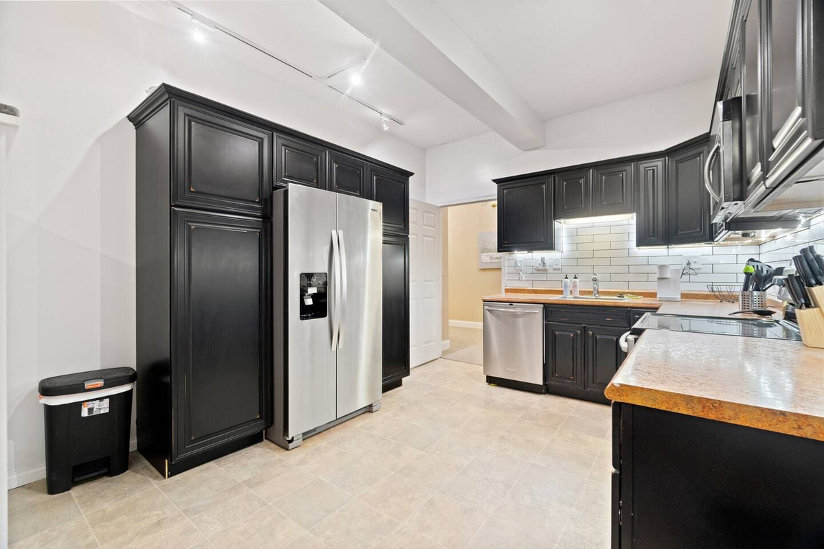 Spacious kitchen featuring a large refrigerator seamlessly integrated with stylish kitchen cabinets for a sleek and functional design.