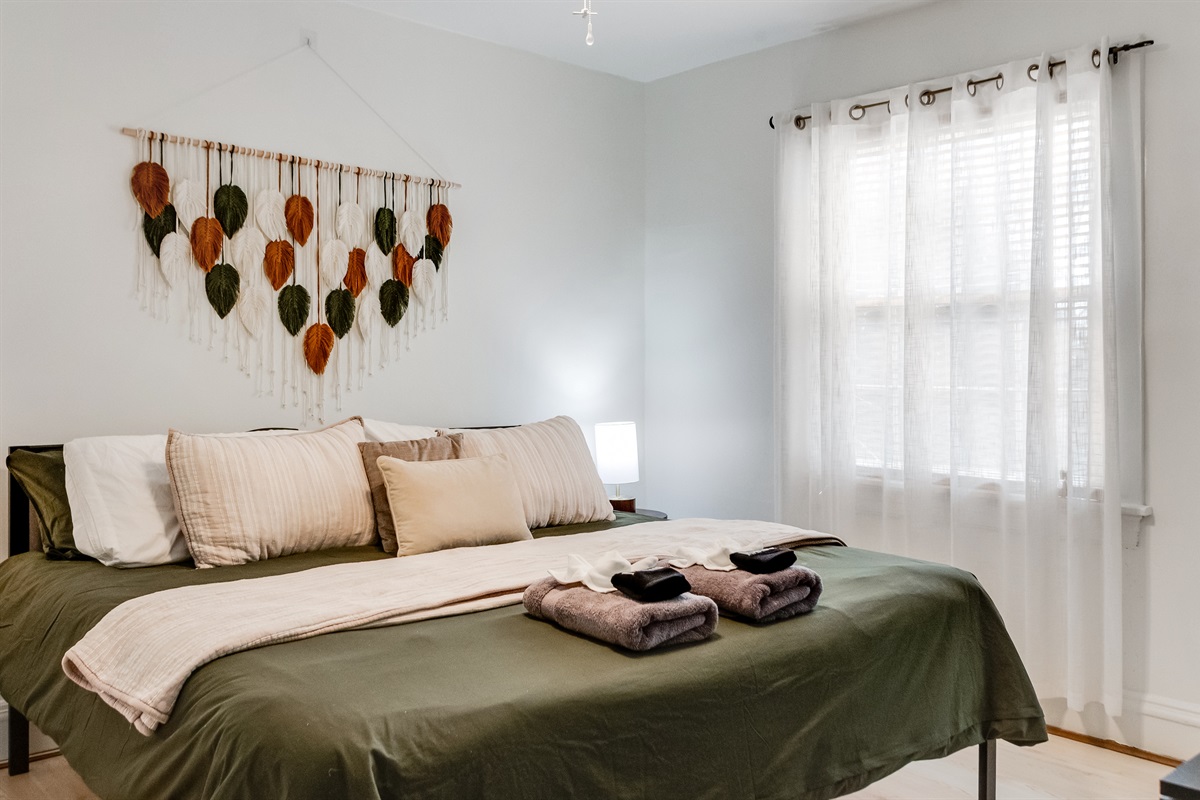 King Bedroom 1: Bright and airy retreat with plush linens and unique leaf-themed decor!