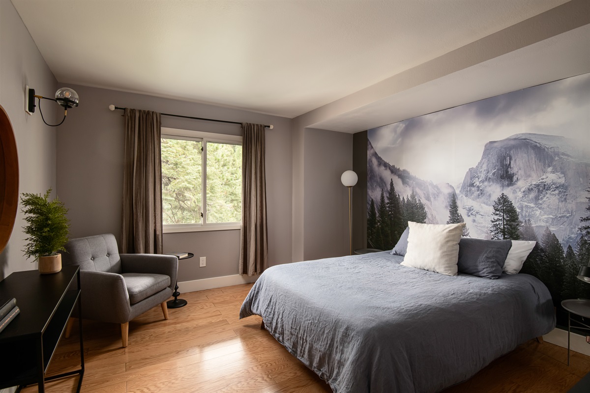 Comfortable bedroom with king bed, natural light, and peaceful forest views—perfect for restful nights during your Lake Arrowhead cabin getaway.