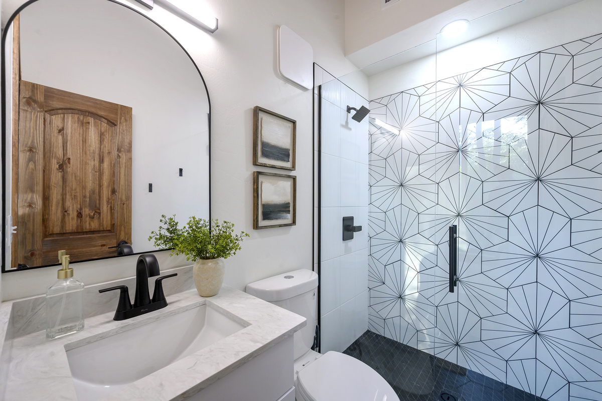 A bright, modern ensuite with a spacious walk-in shower and statement tile that gives this private bath a little personality of its own.
