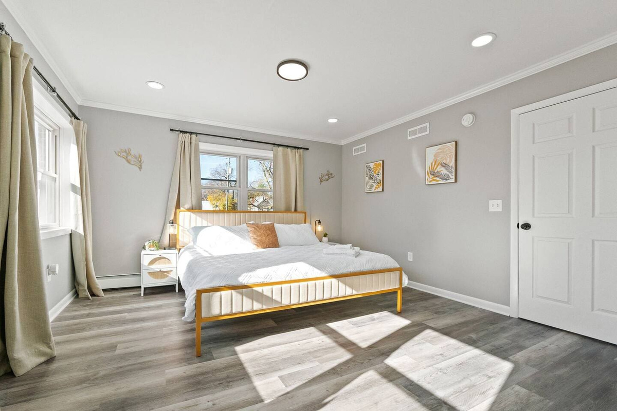 Soft natural light streaming through the windows, creating a warm and inviting glow over the bed.