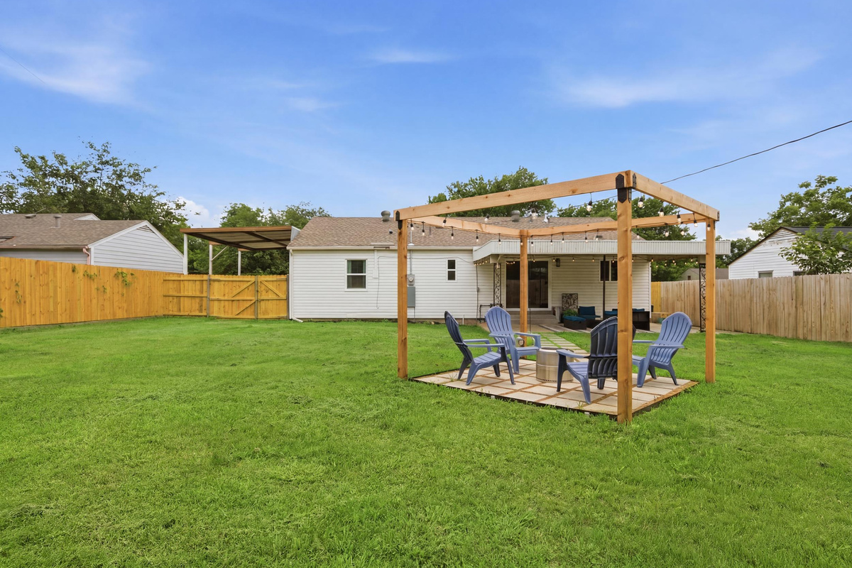 Wood Pergola with string lights, Outdoor Furniture and Fire Pit set on a stone patio. The perfect Arlington evening hangout after a long day exploring the Entertainment District.