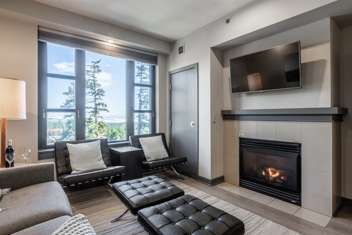 Welcome to Pilot's Peak, where the fireplace anchors the space while expansive windows frame down-valley views toward the Village—warm, inviting, and unmistakably Mammoth.